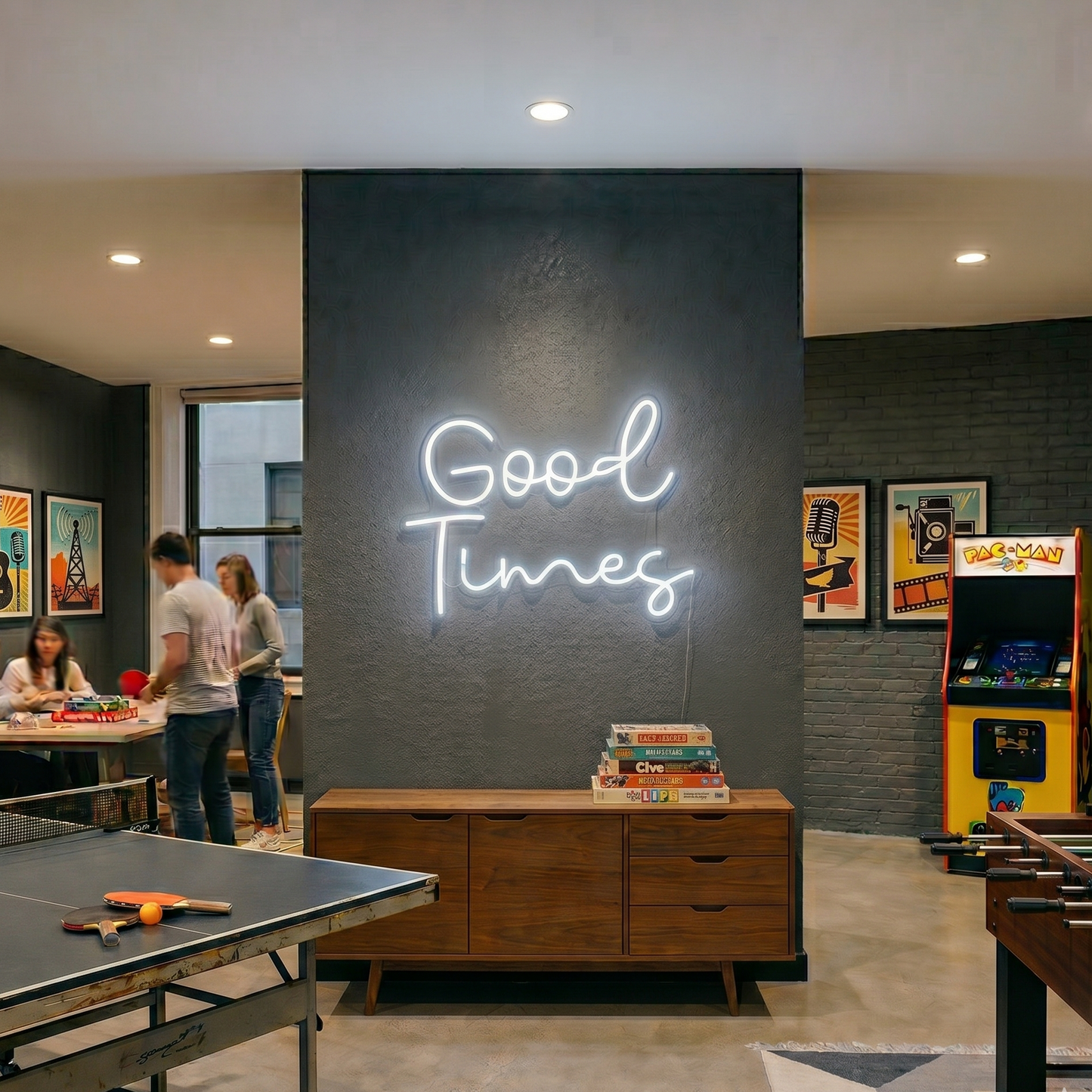 Neon sign reading 'Good Times' in a room with gaming and social furniture.