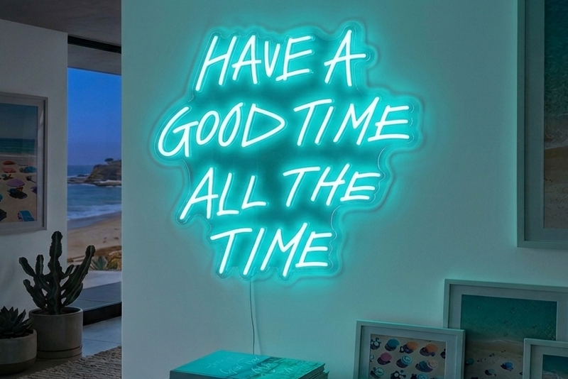 Neon sign reading 'Have a Good Time All the Time' in a room with decor elements.