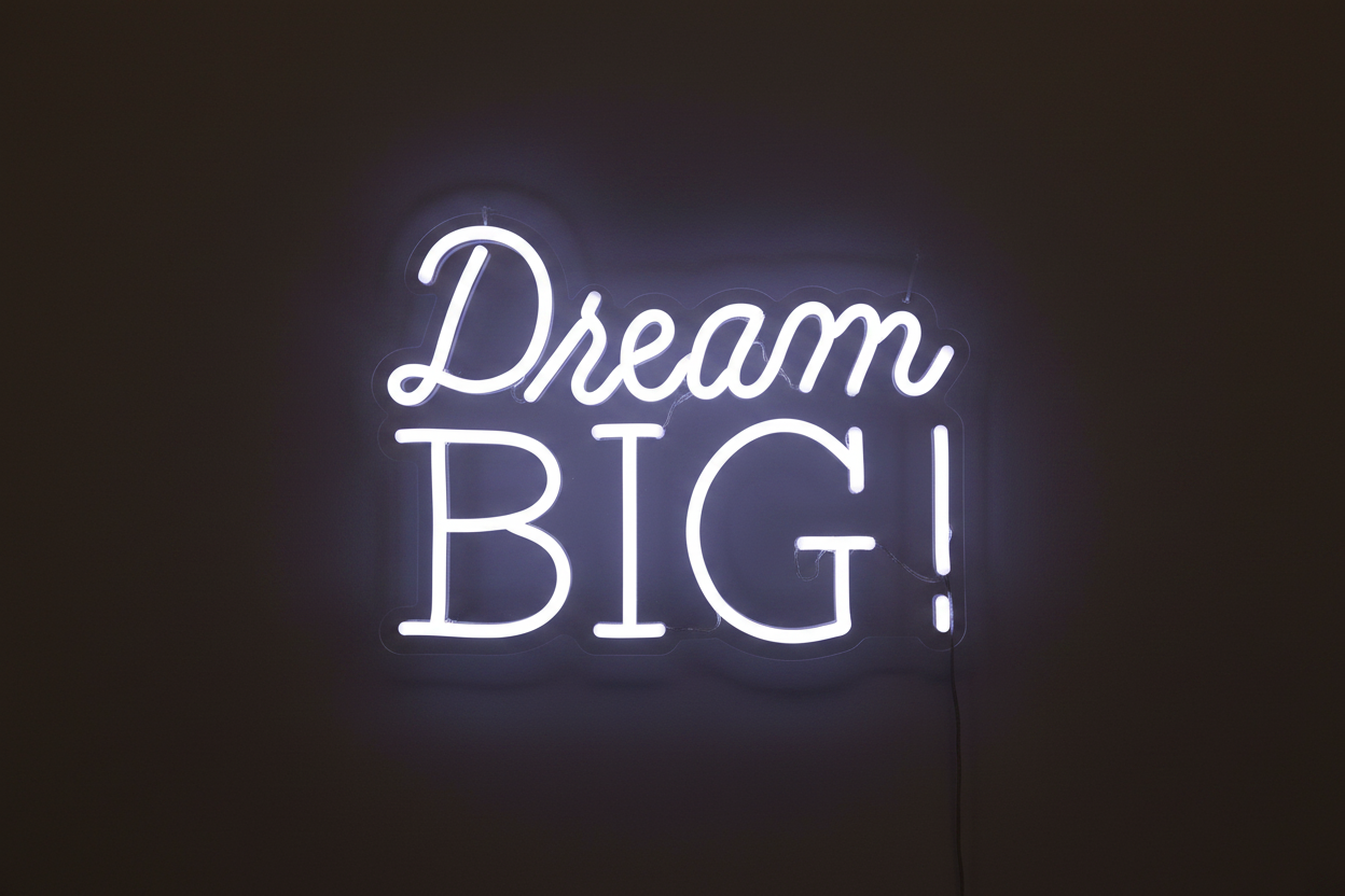 DREAM BIG! white neon sign on a dark charcoal background, clean product photo
